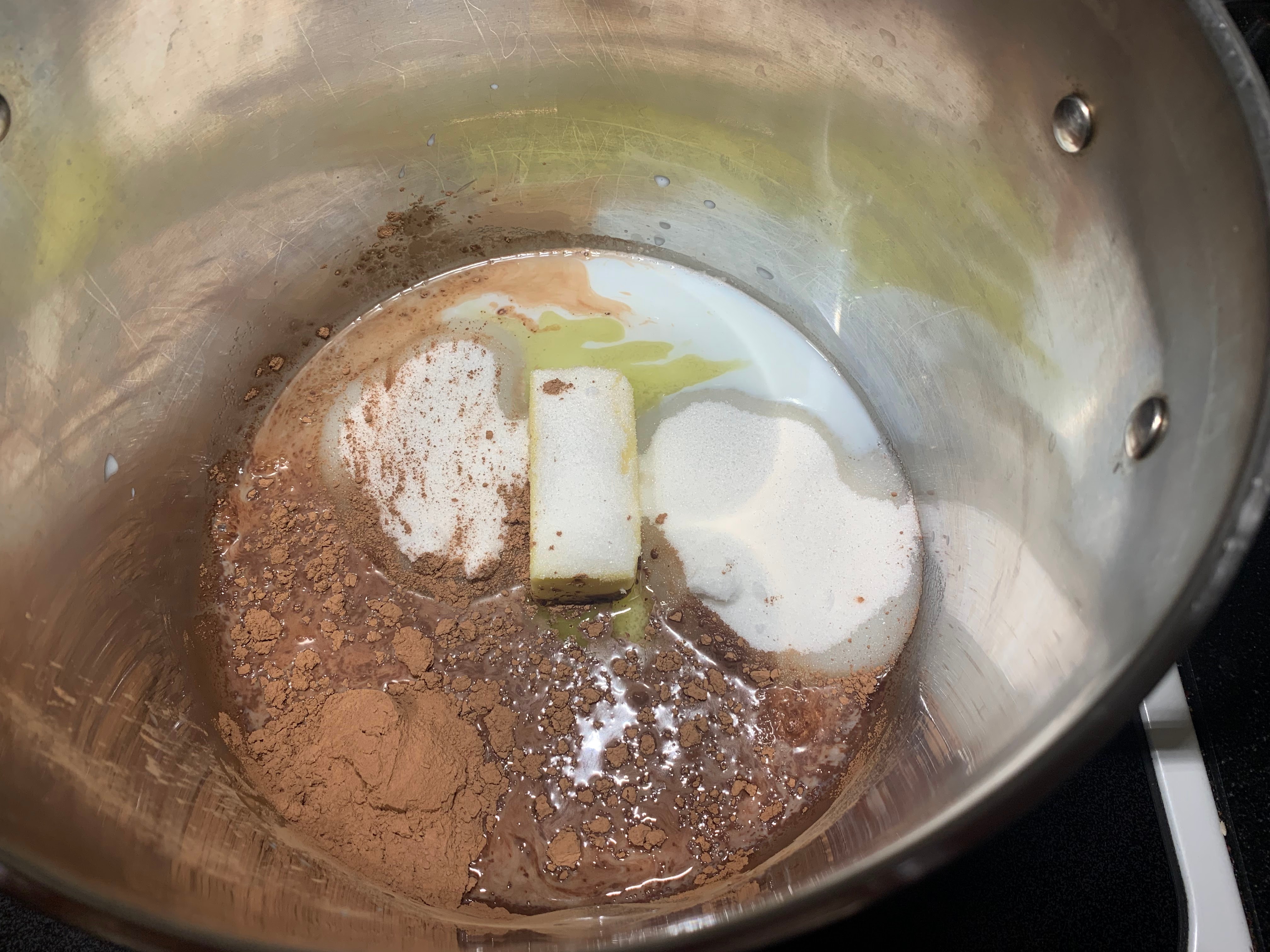 Milk, butter, sugar and cocoa in saucepan