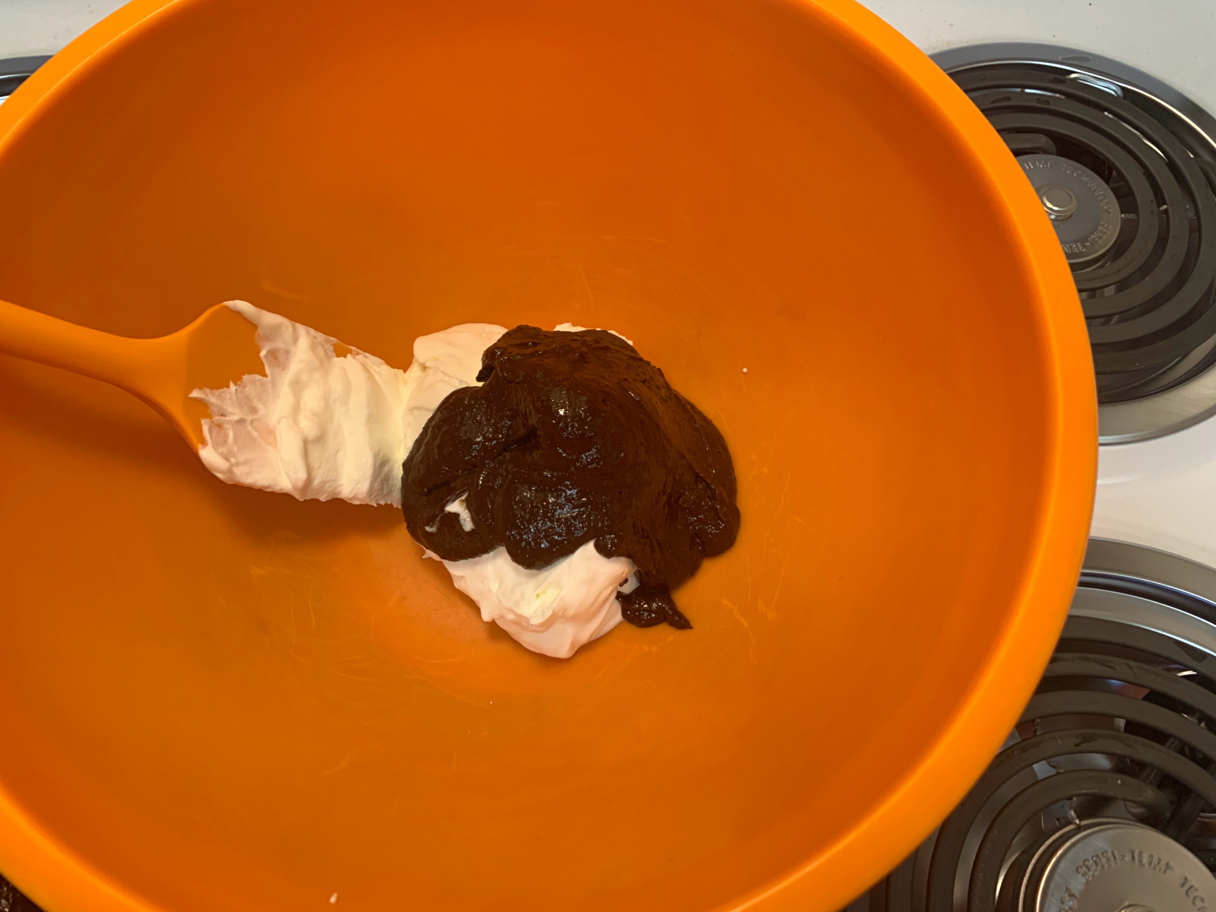 Chocolate being folded into whipped cream